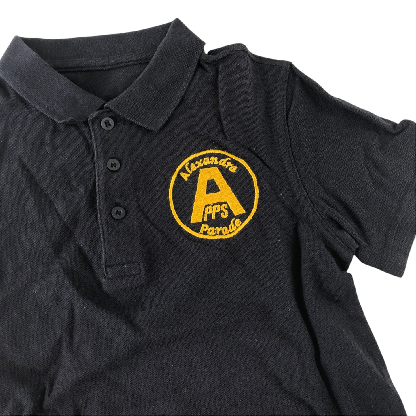 Second-hand Alexandra Parade Primary School navy polo shirt with plain collar and embroidered badge, flat lay view.